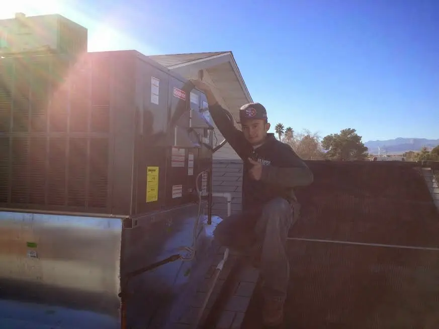 HVAC technician performing AC Tune-Up on a rooftop unit in Van Alstyne